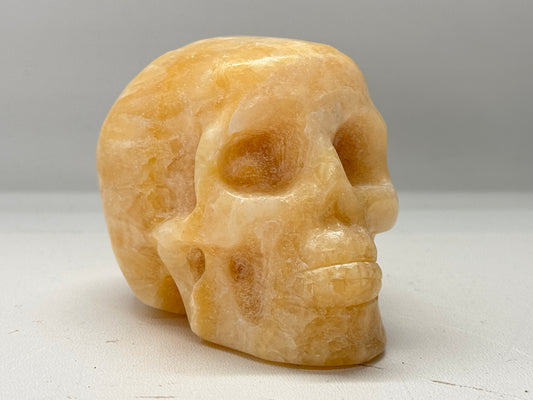 Gepolijste en geslepen schedel van oranje calciet 9 cm