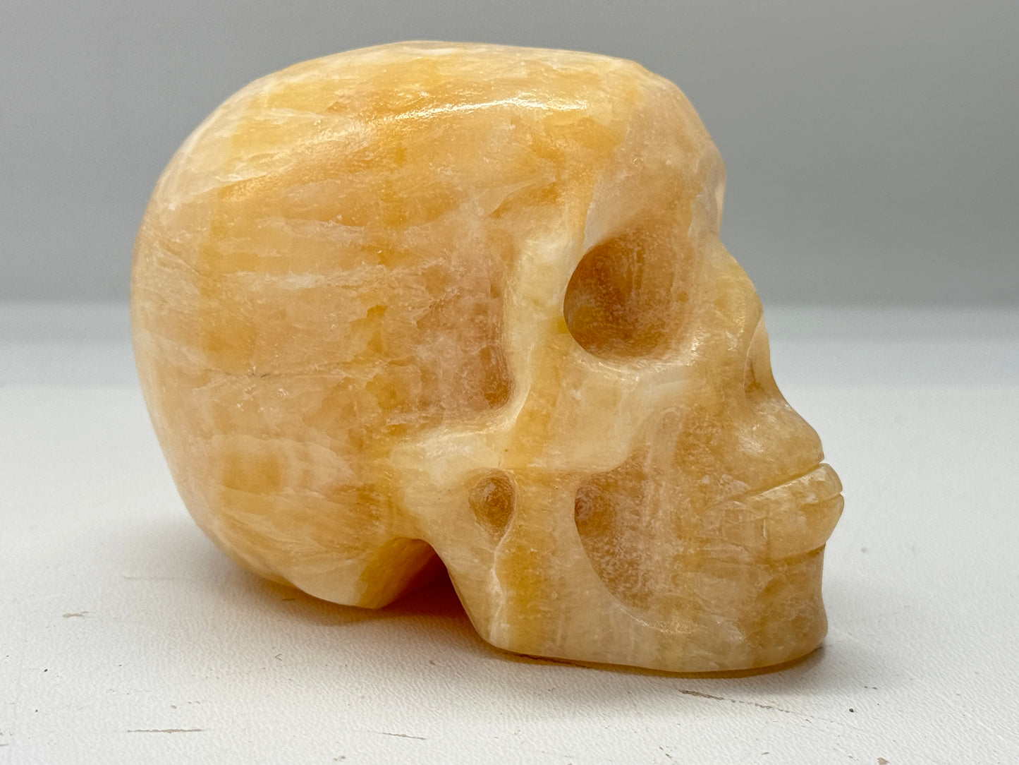 Gepolijste en geslepen schedel van oranje calciet 9 cm